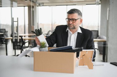 Eski bir çalışan, eşyalarla dolu bir kutuyla ofisten çıkıyor..