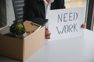 Eski bir çalışan, eşyalarla dolu bir kutuyla ofisten çıkıyor..