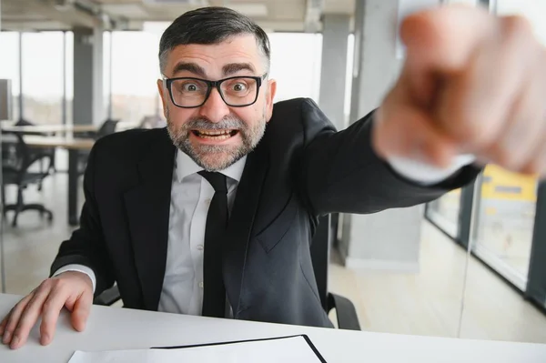 stock image Angry businessman sitting at the table and screaming over