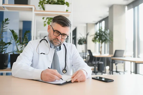 stock image Portrait of serious senior doctor in eyeglasses and in white coat