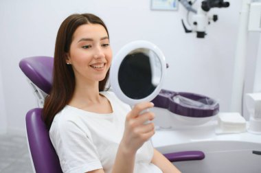 Güzel dişler, genç gülümseyen kadın diş muayene olması.