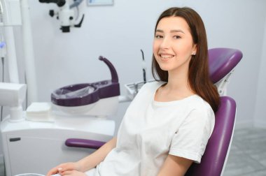Dişçi dolabındaki güzel kız bir doktorun ideal çalışmalarına bakmak için ayna kullanıyor.
