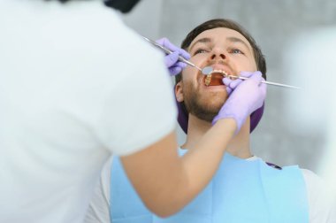 Dişçideki genç adam. Diş bakımı, diş bakımı. Arkaplan için kopyalama alanı olan resim