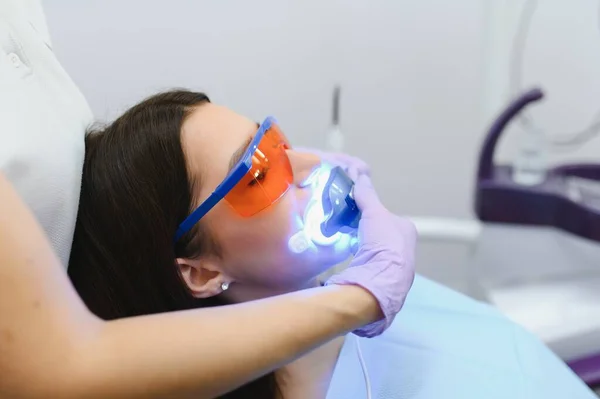 Teeth whitening for woman. Bleaching of the teeth at dentist clinic