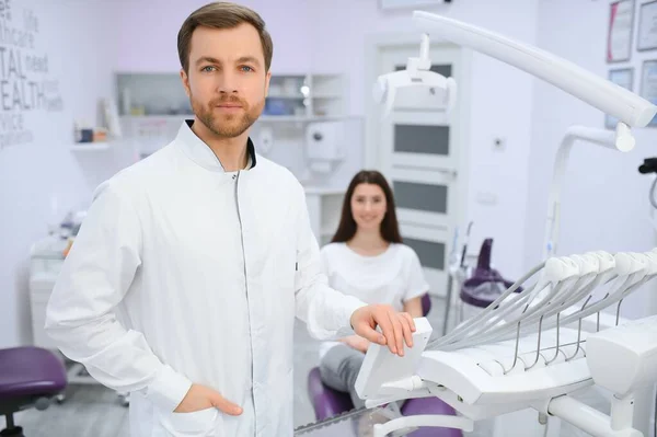 Dentista Masculino Uma Sala Com Equipamentos Médicos Paciente Segundo Plano — Fotografia de Stock