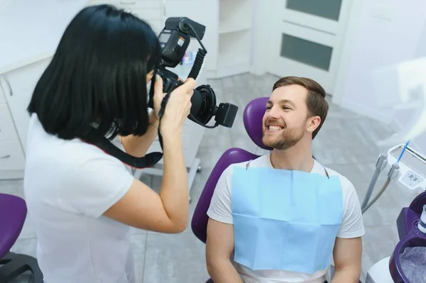 女性歯科医は患者の歯を歯科椅子で撮影します — ストック写真