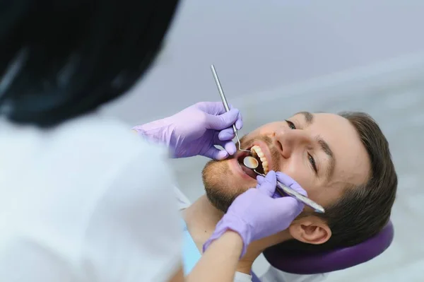 Young man at the dentist. Dental care, taking care of teeth. Picture with copy space for background