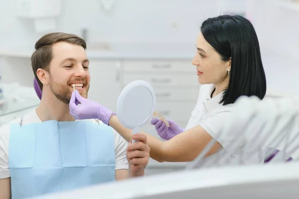 Dentista Verificando Selecionando Cor Dos Dentes Jovem — Fotografia de Stock