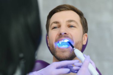 Diş ofisinde closeup portre hasta - ultraviyole ışık ekipmanları.