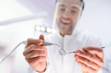 Alt manzara. Elinde bir aletle dişçi.