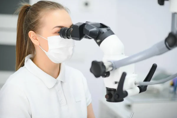 Kvinnlig Tandläkare Med Hjälp Tandmikroskop Som Behandlar Patienttänder Tandklinikens Kontor — Stockfoto