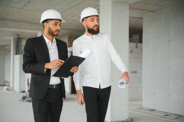 İnşaat mühendisi ve mimar inşaat alanında mavi baskı ile çalışma kavramı