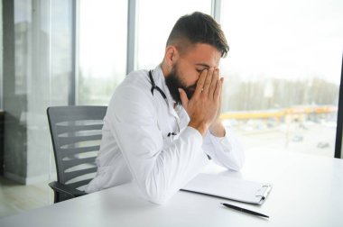 Yorgun ve yorgun Arap erkek doktorun portresi..