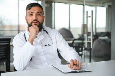 Beyaz önlüklü hoş bir Arap doktorun portresi.