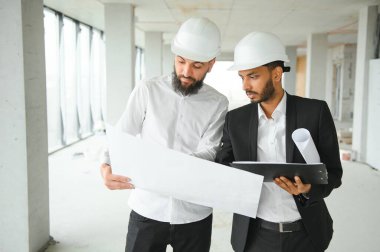 İnşaat mühendisi ve mimar inşaat alanında mavi baskı ile çalışma kavramı