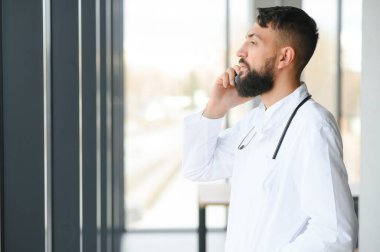 Beyaz önlüklü hoş bir Arap doktorun portresi.