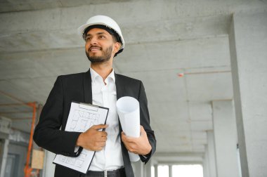 İnşaat alanında duran Asyalı mühendis kendinden emin, mühendis inşaatı başarılı ve hedef planlamada başarılı..