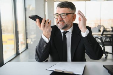Kızgın kızgın sinirli işadamı telefonda kötü hizmet iş kurumsal sorun çözme şikayet konuşurken, rahatsız stresli patron yöneticisi telefon görüşmesi yapmak cep telefonu ile ofis masasında oturup.