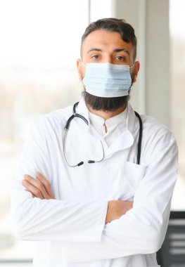 Beyaz önlüklü hoş bir Arap doktorun portresi.