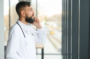 Klinikte duran genç bir doktorun portresi.