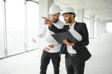 Hint ve Arap mühendisler. Müteahhit ve mimar büyük bir proje üzerinde çalışmaktan bahsediyor. İnşaat sürecinde bina içi