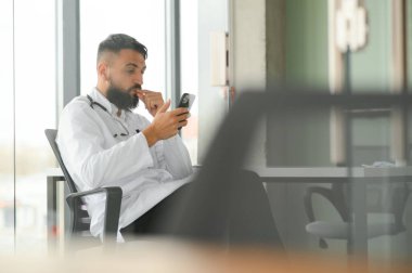 Beyaz önlüklü hoş bir Arap doktorun portresi.