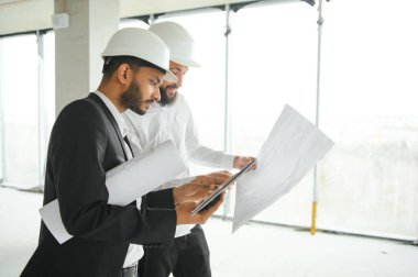 İnşaat mühendisi ve mimar inşaat alanında mavi baskı ile çalışma kavramı