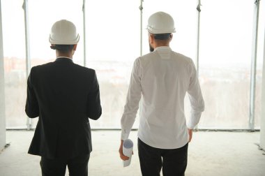 Çok ırklı iş adamları. İnşaat konsepti. Hint ve Arap mühendisler inşaatı denetliyor.