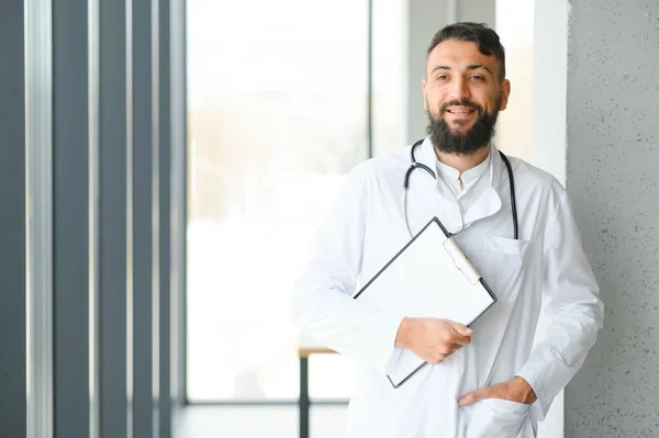 Przystojny Latynoski Lekarz Noszący Stetoskop Klinice Uśmiechem Twarzy — Zdjęcie stockowe
