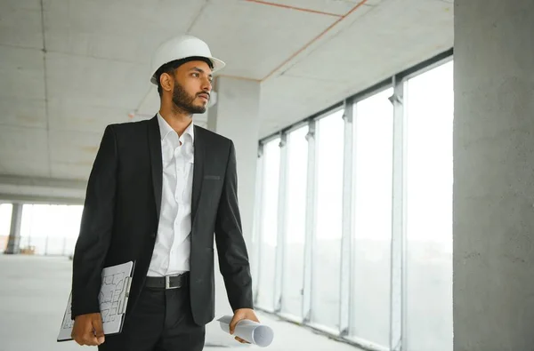 Asian engineer handsome man or architect with white safety helmet in construction site. Standing at modern building construction. Worker asian man working project building.
