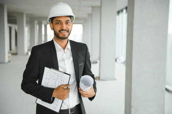 Asian engineer handsome man or architect with white safety helmet in construction site. Standing at modern building construction. Worker asian man working project building.