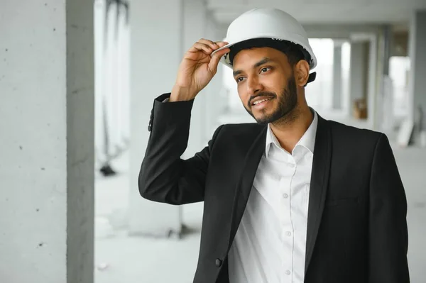 architecture, construction business and building concept - happy smiling indian male architect in helmet