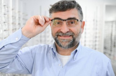 Glasses check, senior vision and elderly man at a consulting optometry clinic for wellness. Happy, smile and old face with lens, frame and eyewear choice in a store for help getting a prescription
