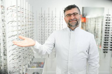 Hastanedeki gözlüklü yakışıklı bir göz doktorunun portresi.