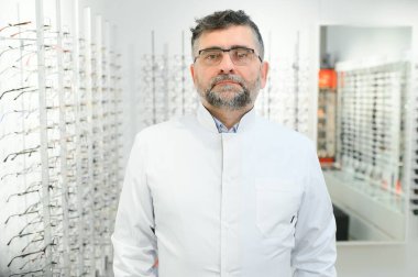 Hastanedeki gözlüklü yakışıklı bir göz doktorunun portresi.