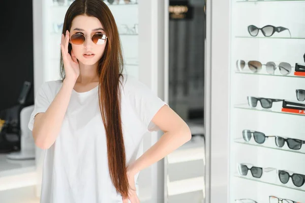 Молодая Женщина Выбирает Солнечные Очки Магазине Оптики — стоковое фото