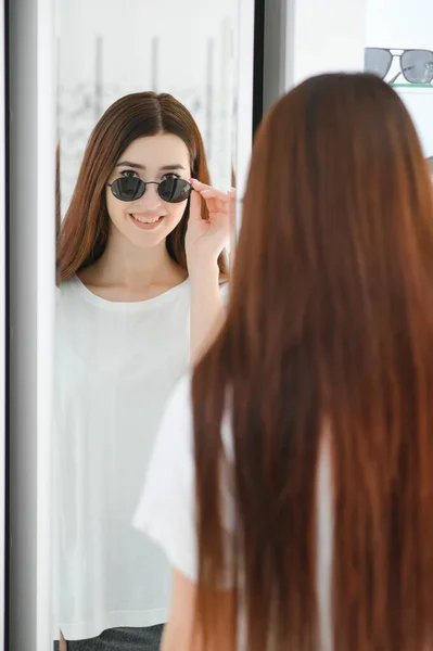 Jonge Vrouw Kiest Zonnebril Voor Zichzelf Een Optiek Winkel — Stockfoto