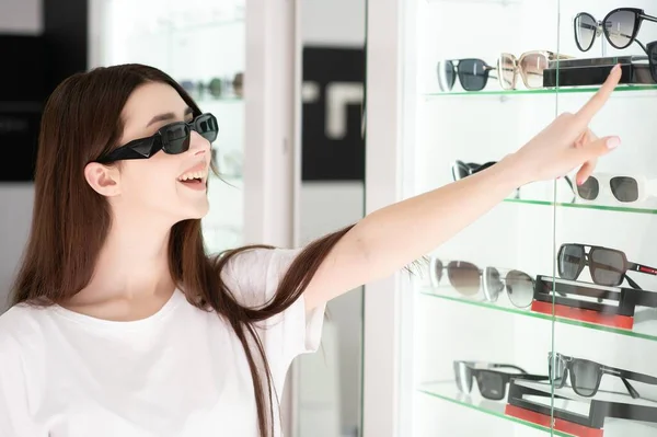 Junge Frau Sucht Sich Sonnenbrille Optikgeschäft Aus — Stockfoto