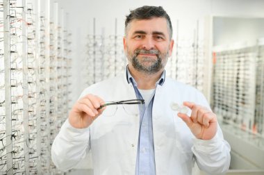 Erkek doktor kontakt lens durumda ve gözlük, holding