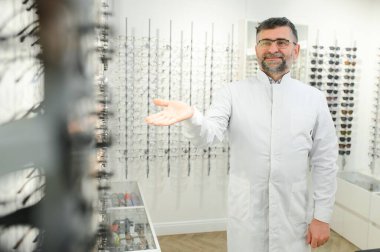 Hastanedeki gözlüklü yakışıklı bir göz doktorunun portresi.