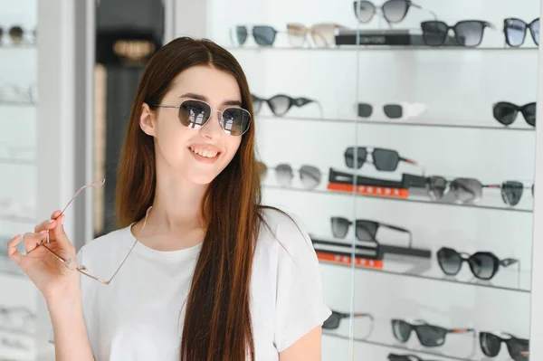 Mladá Žena Vybere Sluneční Brýle Pro Sebe Obchodě Optikou — Stock fotografie