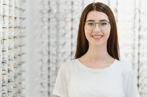 stock image Young Woman with Eyeglasses in Optical Store - Beautiful girl wearing glasses in optician shop.