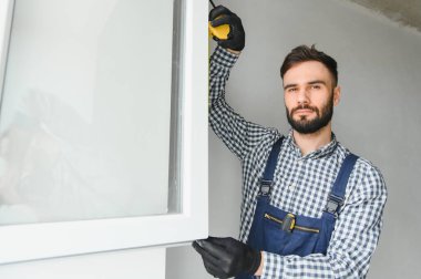 İçeriye plastik pencere kuran işçiler.