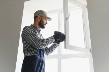 İnşaat işçisi eve pencere kuruyor.