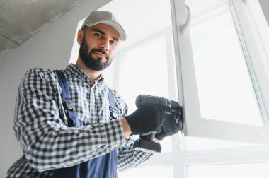 İnşaat işçisi eve pencere kuruyor.