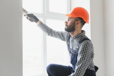 Fırça boyama ahşap çit üzerinde beyaz holding işçi el.