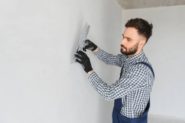 Genç bir işçi yapım onarım odasında.