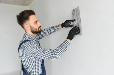 Genç bir işçi yapım onarım odasında.
