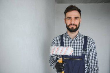 Gri beton duvarın arkasında gülen inşaat işçisi. Yenileme. metin için yer.