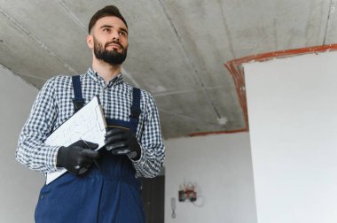 İnşaat sürecinde apartman malzemeleri için hesaplamalar yapan kendini işine adamış bir işçi